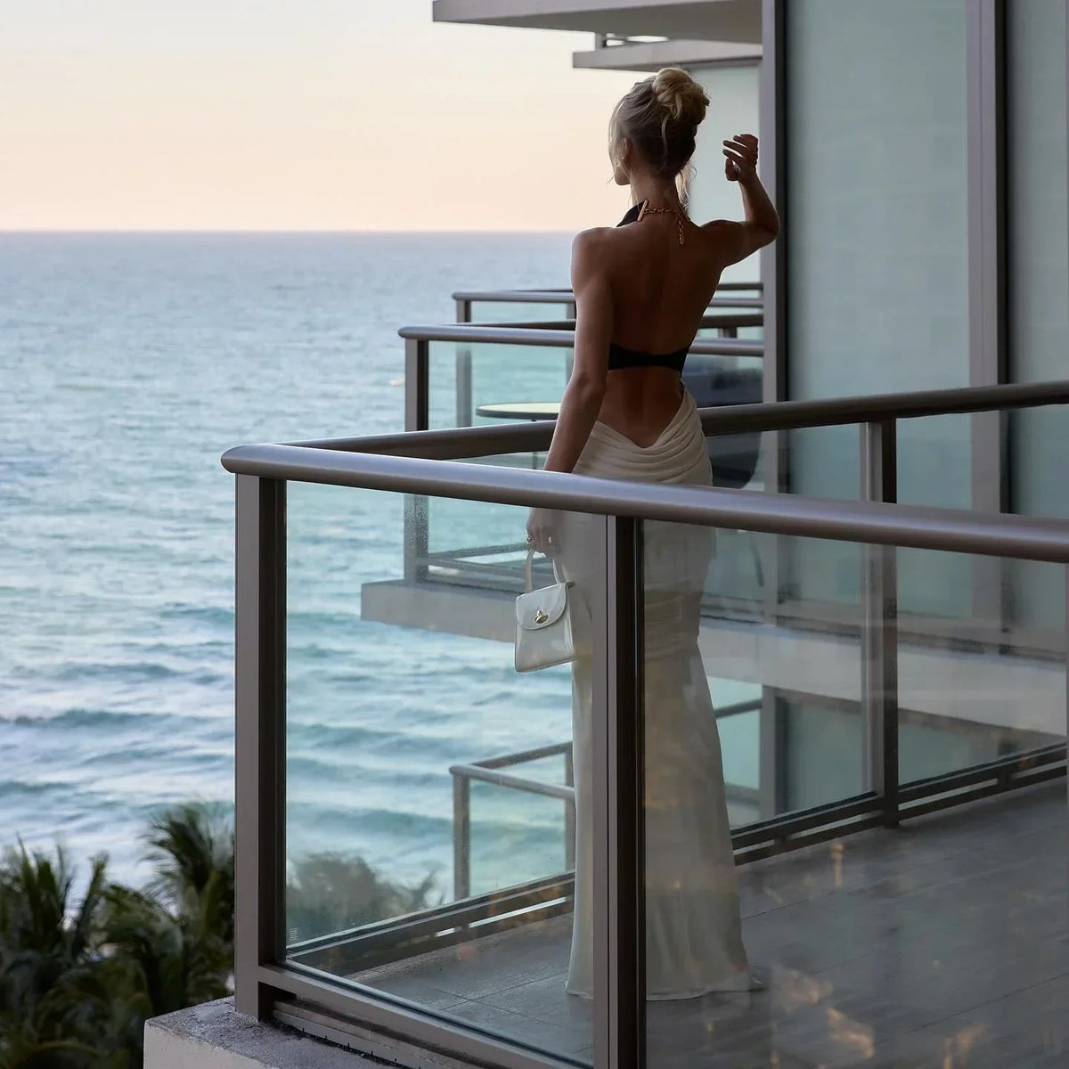 Black and White Backless Maxi Dress – lifestyle back view by the sea
