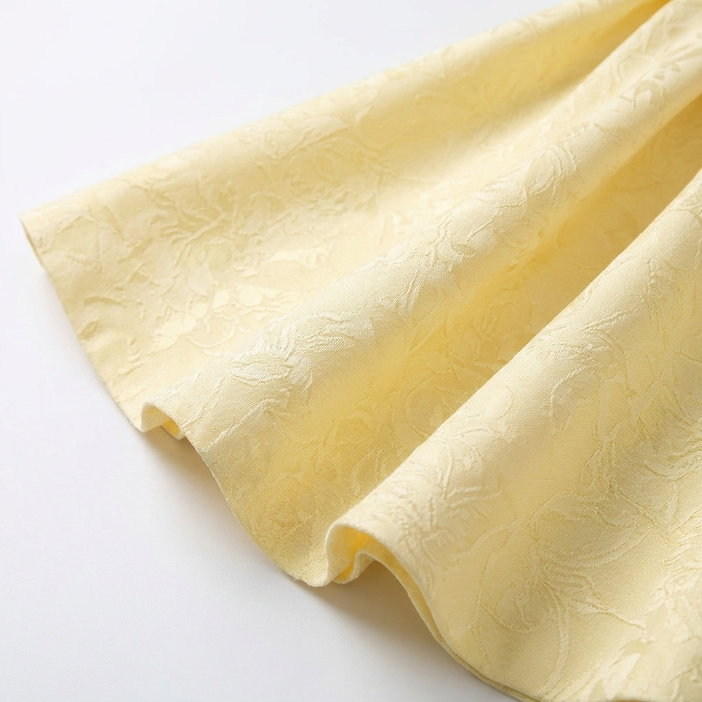 Jacquard Halter Skater Mini Dress with Bow Back in Yellow – close-up detail of jacquard skirt