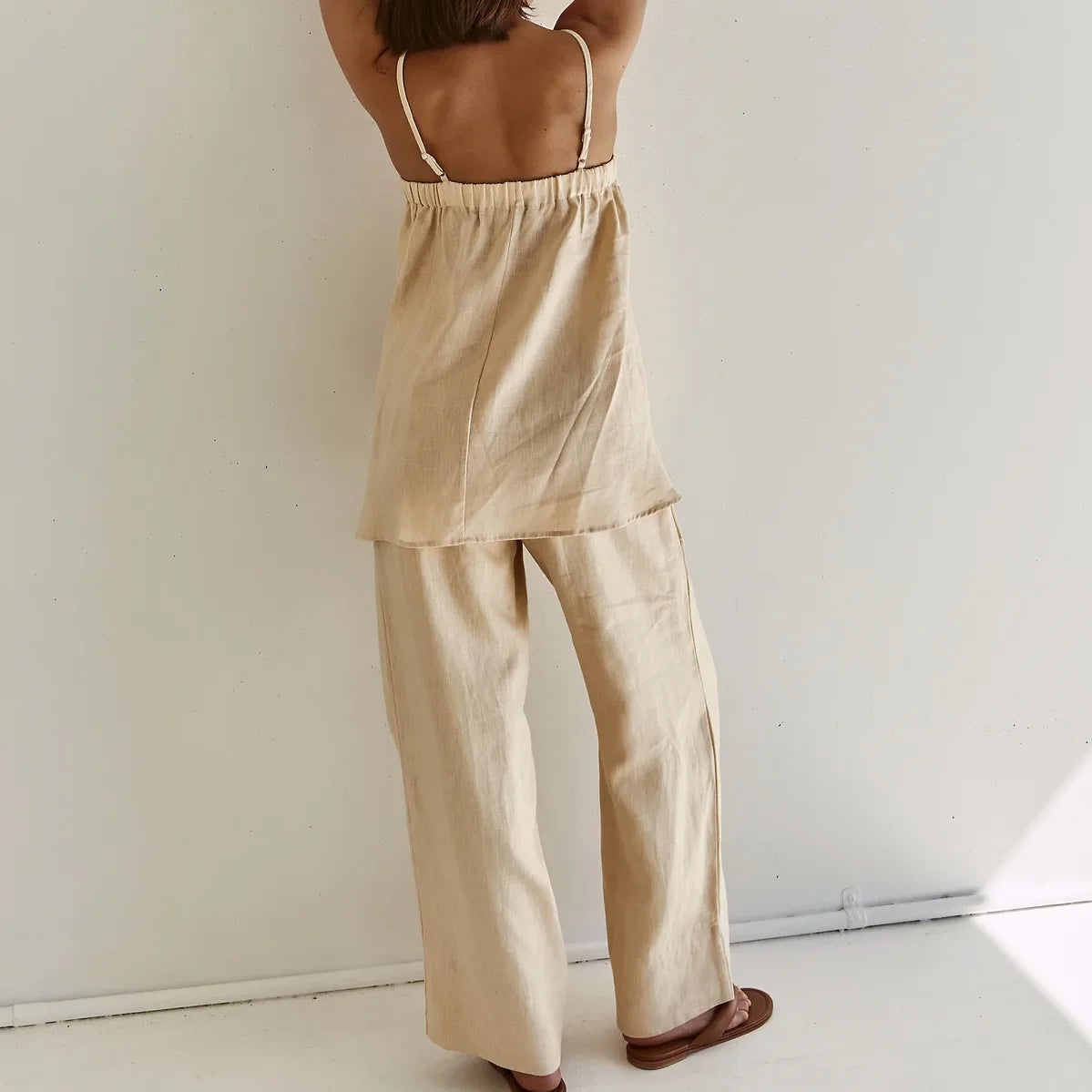 Back view of beige trapeze cami with thin straps and wide leg pants