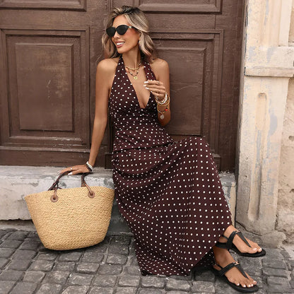 Model seated in brown polka dot halter maxi dress on a doorstep