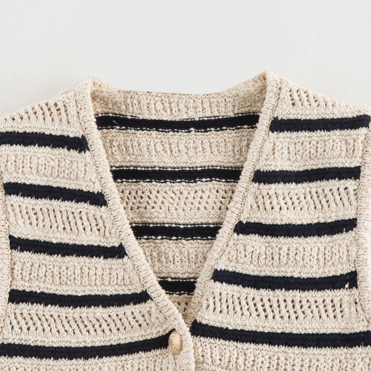 Close-up of V-neckline and open knit on striped vest