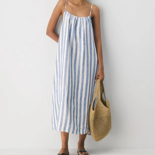 Front view of blue and white striped slip maxi dress with woven bag