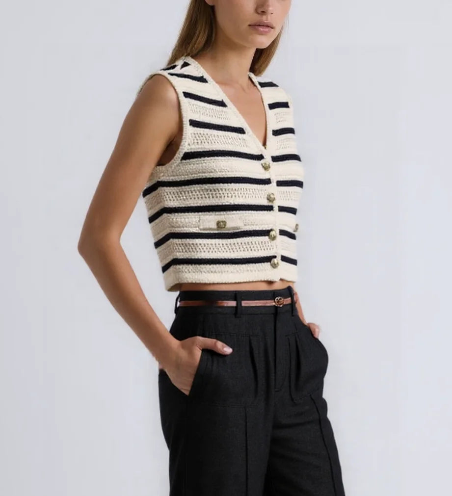 Model in cream and navy striped crochet knit vest with black trousers