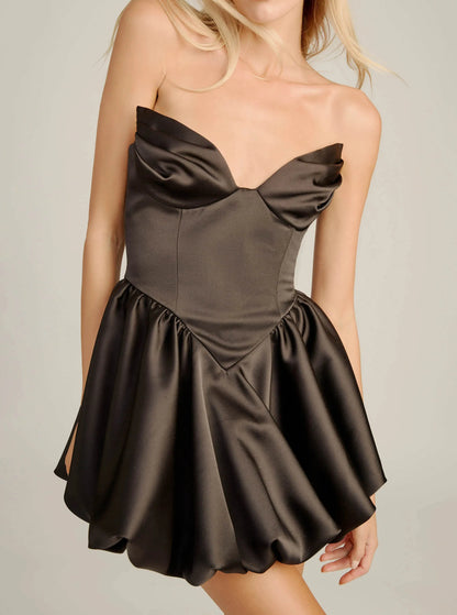 Close-up of dark satin corset mini dress showing draped sweetheart cups, seamed bodice and dropped V-waist (warmer lighting)