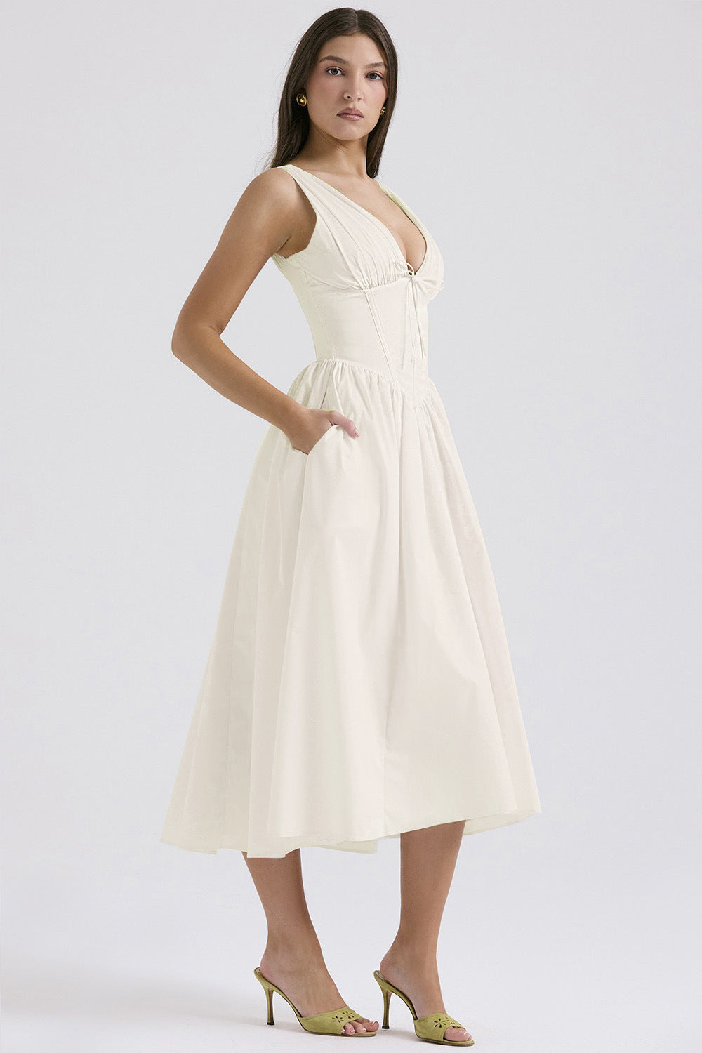 Ruched V-Neck Flared Midi Dress in White – three-quarter view with hand in pocket