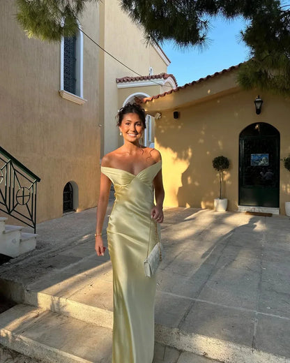 Yellow Off-Shoulder Draped Maxi Dress – front view with clutch