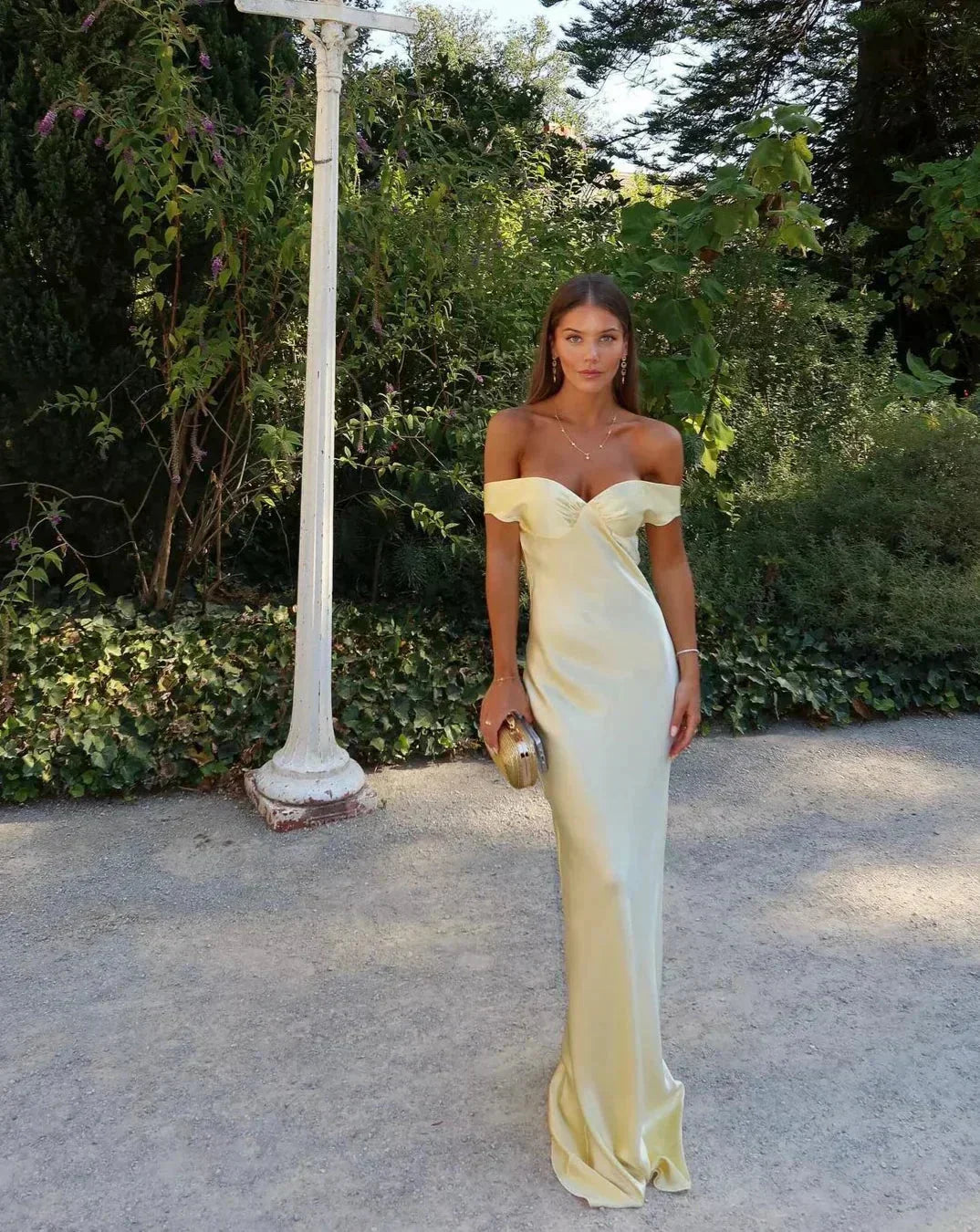 Yellow Off-Shoulder Draped Maxi Dress – front view in a garden