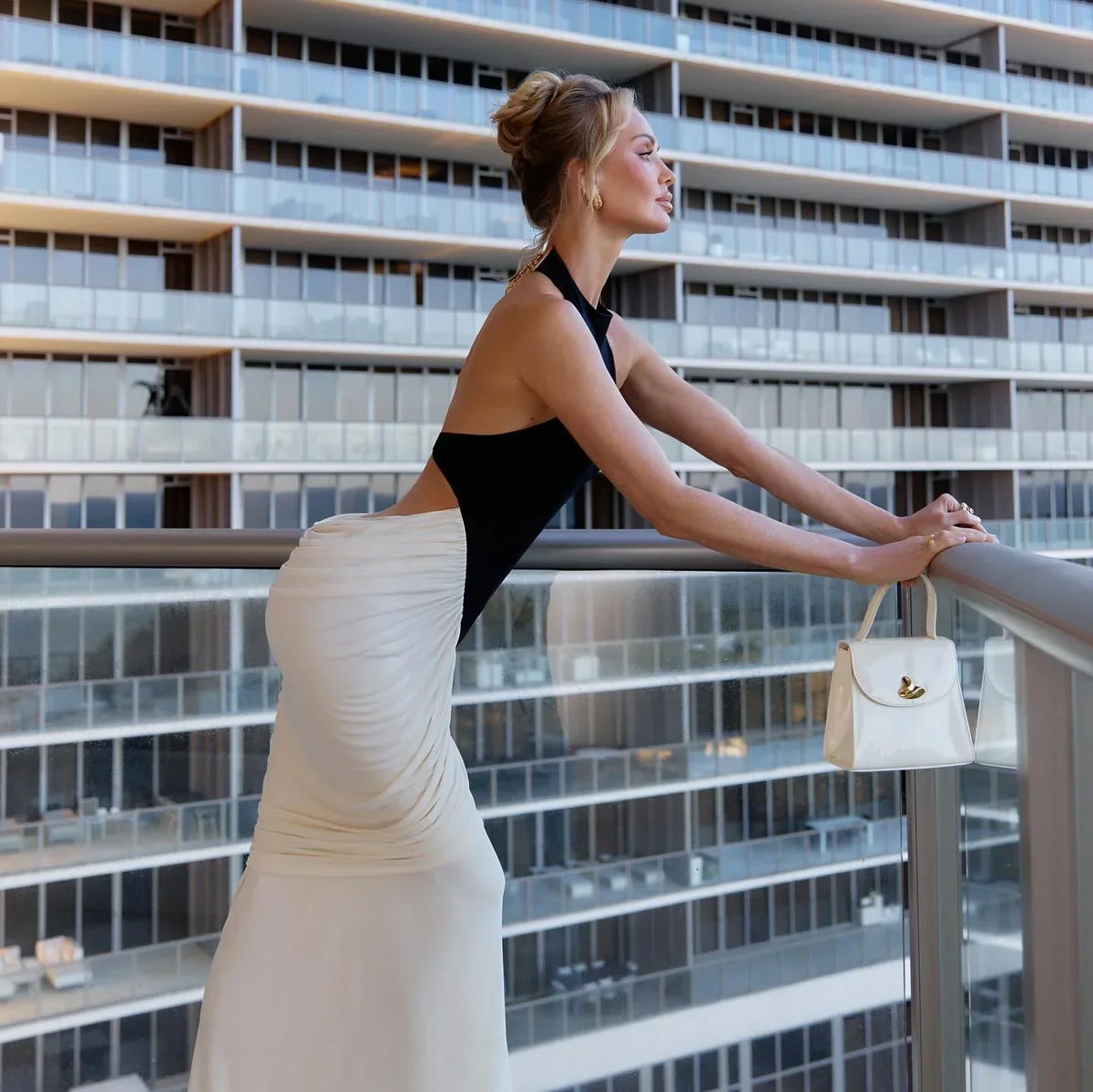 Black and White Backless Maxi Dress – lifestyle side view on a balcony